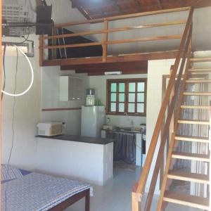 a kitchen with a staircase leading up to a kitchen with a sink at Chale Cantão de Itamambuca in Ubatuba