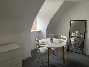 a white dining room with a table and a mirror at 2 person holiday home in Ringkøbing in Ringkøbing +29 photos