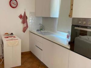 a kitchen with white cabinets and a sink at Holiday Home in Stintino near La Pelosa Beach in Stintino +30 photos
