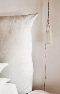 a white pillow and a lamp next to a bed at La Bâtisse en Blanc in Golfe-Juan