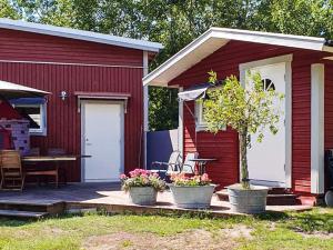 a red house with a patio with a table and chairs at 6 person holiday home in MÖNSTERÅS in Mönsterås