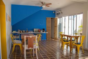 a kitchen with yellow chairs and a blue wall at Esterito Hostel in La Paz