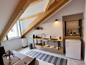 an attic kitchen with a sink and a refrigerator at Jacuzzi Turin Center - Serendipity Suite in Turin
