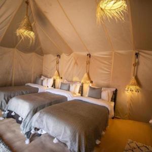 Postel nebo postele na pokoji v ubytování Sahara Eyes Luxury Camp + 16 fotografií