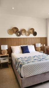 a bedroom with a bed with hats on the wall at Con jacuzzi privado, laguna y Paddle board in Cartagena de Indias +65 photos