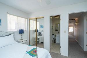 a bedroom with a white bed and a bathroom at River Love, private dock Moovalya Keys in Parker
