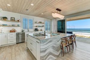 a kitchen with a large island with a table and chairs at 226 South Fletcher 3rd Floor home in Fernandina Beach +41 photos