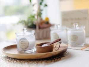 a wooden plate with two jars and a spoon at JR Kyushu Hotel Kagoshima in Kagoshima