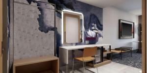 un baño con lavabo y espejo en Tempo By Hilton San Diego Del Mar, en San Diego