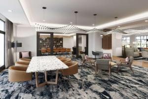 Un vestíbulo con una mesa y sillas y una biblioteca. en Tempo By Hilton San Diego Del Mar, en San Diego