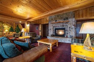 a living room with a couch and a stone fireplace at The Lodge at Brainerd Lakes, Trademark Collection by Wyndham in Baxter