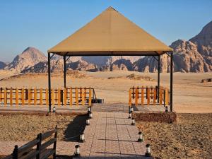a gazebo with two benches in the desert at Wadi Rum star in Wadi Rum