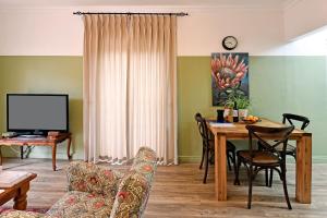 una sala de estar con una mesa y un sofá en The Protea Apartment no01, en Franschhoek