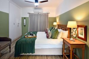 Un dormitorio con una gran cama blanca con paredes verdes. en The Protea Apartment no01, en Franschhoek 18 fotos más