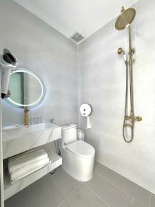 a bathroom with a toilet and a sink and a mirror at Blue Star Viên Hotel in Binh Tien +39 photos