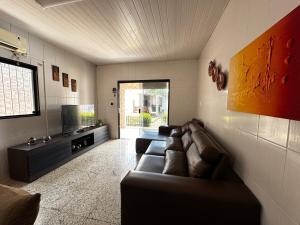 a living room with a couch and a flat screen tv at Enseada dos corais - Cabo de Santo Agostinho com piscina grande in Cabo de Santo Agostinho