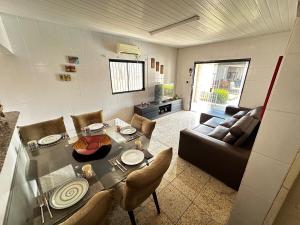 a living room with a table and a couch at Enseada dos corais - Cabo de Santo Agostinho com piscina grande in Cabo de Santo Agostinho