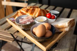 a wooden tray with eggs and bread on a table at Mackenzie Pass Retreat by Tiny Away in Burkes Pass