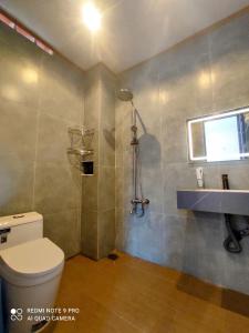 a bathroom with a toilet and a sink and a window at Tổ Homestay in Tân Phú