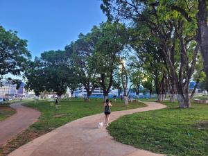 a woman walking a dog on a path in a park at Belissímo in Brasília
