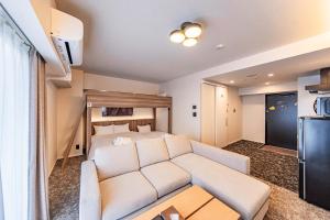 a living room with a couch and a bed at Apartment Hotel 11 Shinsekai in Osaka