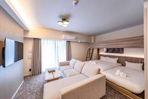 a hotel room with a couch and a bed at Apartment Hotel 11 Shinsekai in Osaka