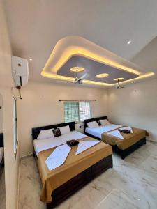 1 dormitorio con 2 camas y techo con luces. en Reddys Guest House, en Hampi