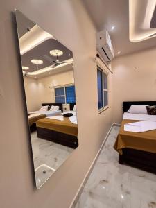 una habitación con dos camas y un espejo en Reddys Guest House, en Hampi 7 fotos más