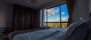 sypialnia z łóżkiem i dużym oknem w obiekcie The Hills View w mieście Nairobi