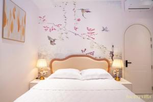 a bedroom with a bed with birds and flowers on the wall at Happy Villa in Bình Tú
