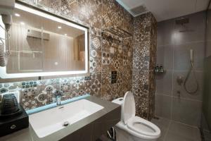 a bathroom with a sink and a toilet and a mirror at Eden Hotel in Ho Chi Minh City