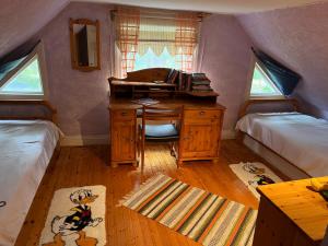 1 dormitorio con escritorio y 1 dormitorio con 2 camas en Hafners Ferienhaus, en Gullringen