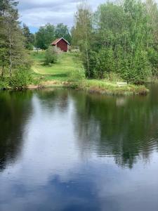 una vista de un lago con un granero rojo en el fondo en Hafners Ferienhaus, en Gullringen 23 fotos más