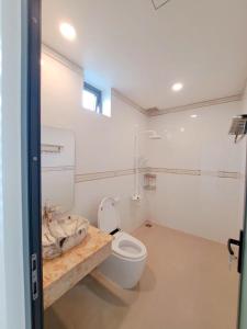 a white bathroom with a toilet and a sink at Nhà ở tại Cam Ranh in Thôn Xuan Ninh