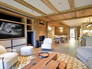 a living room with a couch and a table at Appartement luxe 3 chambres avec spa et accès direct aux pistes - FR-1-613-51 in Les Allues