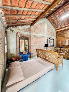 a bedroom with two beds and a brick wall at Griya Rejodani Homestay Jogja in Ngaglik