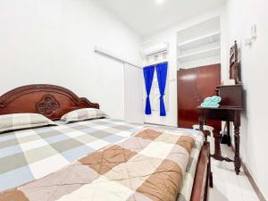 a bedroom with a bed with a checkeredkered floor at Griya Rejodani Homestay Jogja in Ngaglik