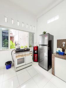 a kitchen with a stainless steel refrigerator and a stove at Griya Rejodani Homestay Jogja in Ngaglik