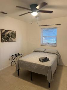 een slaapkamer met een bed en een plafondventilator bij Fauna Bizcaya in Gold Coast Heliport