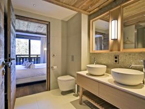 łazienka z 2 umywalkami i sypialnia w obiekcie Appartement lumineux avec balcon à 2 chambres doubles et services inclus, skis aux pieds - FR-1-613-65 w mieście Les Allues +28 zdjęć