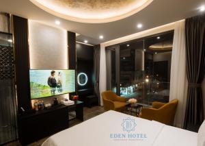 a hotel room with a bed and a flat screen tv at Eden Hotel in Ho Chi Minh City +39 photos