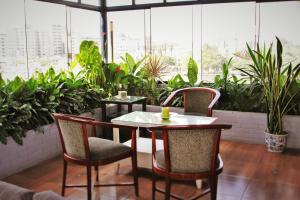 stół i krzesła w pokoju z roślinami w obiekcie Daniel's Apart Hotel w mieście Lima