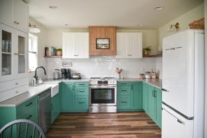 eine Küche mit grünen Schränken und einem weißen Kühlschrank in der Unterkunft Prairie Cottage, a Fresh Farmhouse in Snohomish