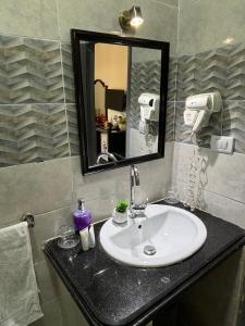 a bathroom with a sink and a mirror at K Boutique Hotel - Pyramids & GEM - Roof in Cairo +64 photos