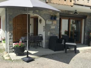 a patio with an umbrella and chairs and tables at Chalet Douillet à Châtel - 5 Pers., 3 Ch. - FR-1-676-212 in Châtel