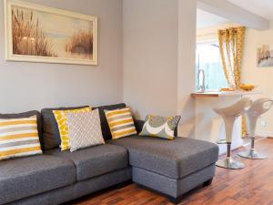 a living room with a gray couch with colorful pillows at The Horseshoes in Hornsea