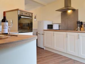 a kitchen with white cabinets and a bottle of wine at The Horseshoes in Hornsea