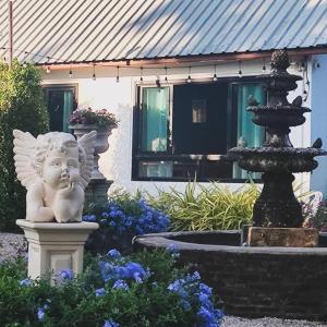 eine Statue eines Engels neben einem Brunnen in der Unterkunft Payim farm พายิ้มฟาร์ม in Ban Nam Khrai + 8 Fotos