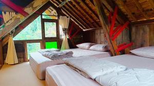 a room with three beds in a building with windows at Kebun Hanoman Private Villa in Pablengan