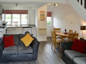 ein Wohnzimmer mit Sofa und Tisch in der Unterkunft Pottergate Cottage in Wroxham